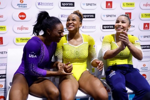 The three medallists, Simone Biles (L), Rebeca Andrade (C) and a second Brazilian Flavia Saraiva await the results in the floor final at the World Championships in Antwerp in October 2023