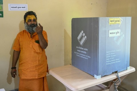 Hindu monk Mahant Haridas Udaseen holds up his finger marked with indelible ink showing he has voted