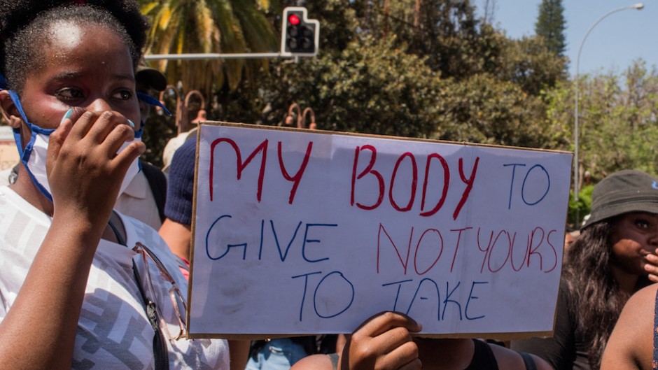 File: A protester holds a placard during a GBV protest.AFP/Hildegard Titus