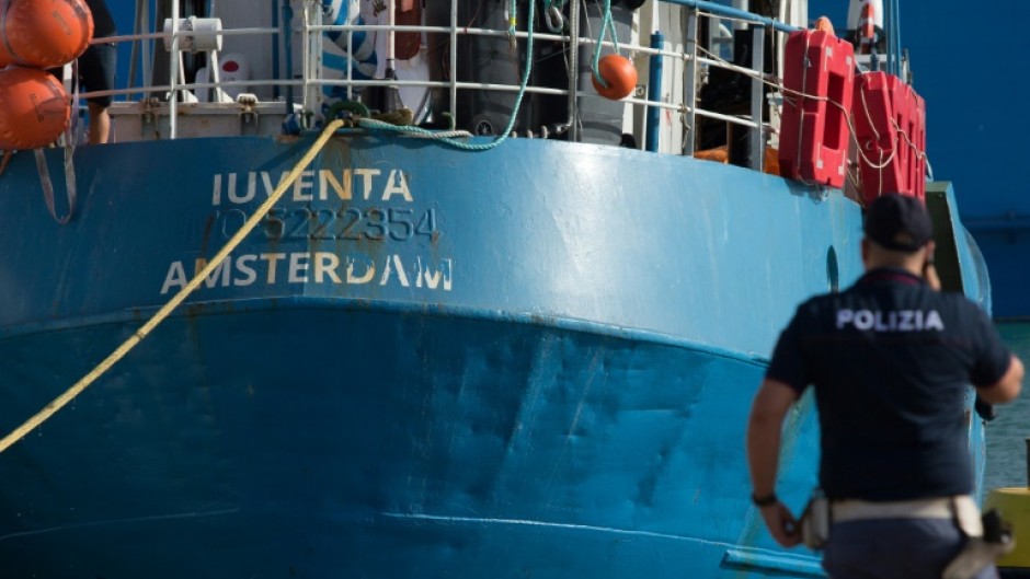 An Italian police officer stands by the Iuventa rescue ship run by German NGO Jugend Rettet (Youth Saves) 