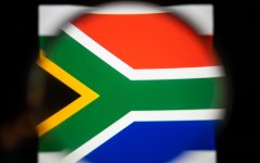 File: View of the South African flag with a magnifying glass.