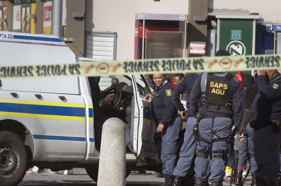 File: Police officers at the scene of a murder of an alleged gang member. AFP/Rodger Bosch