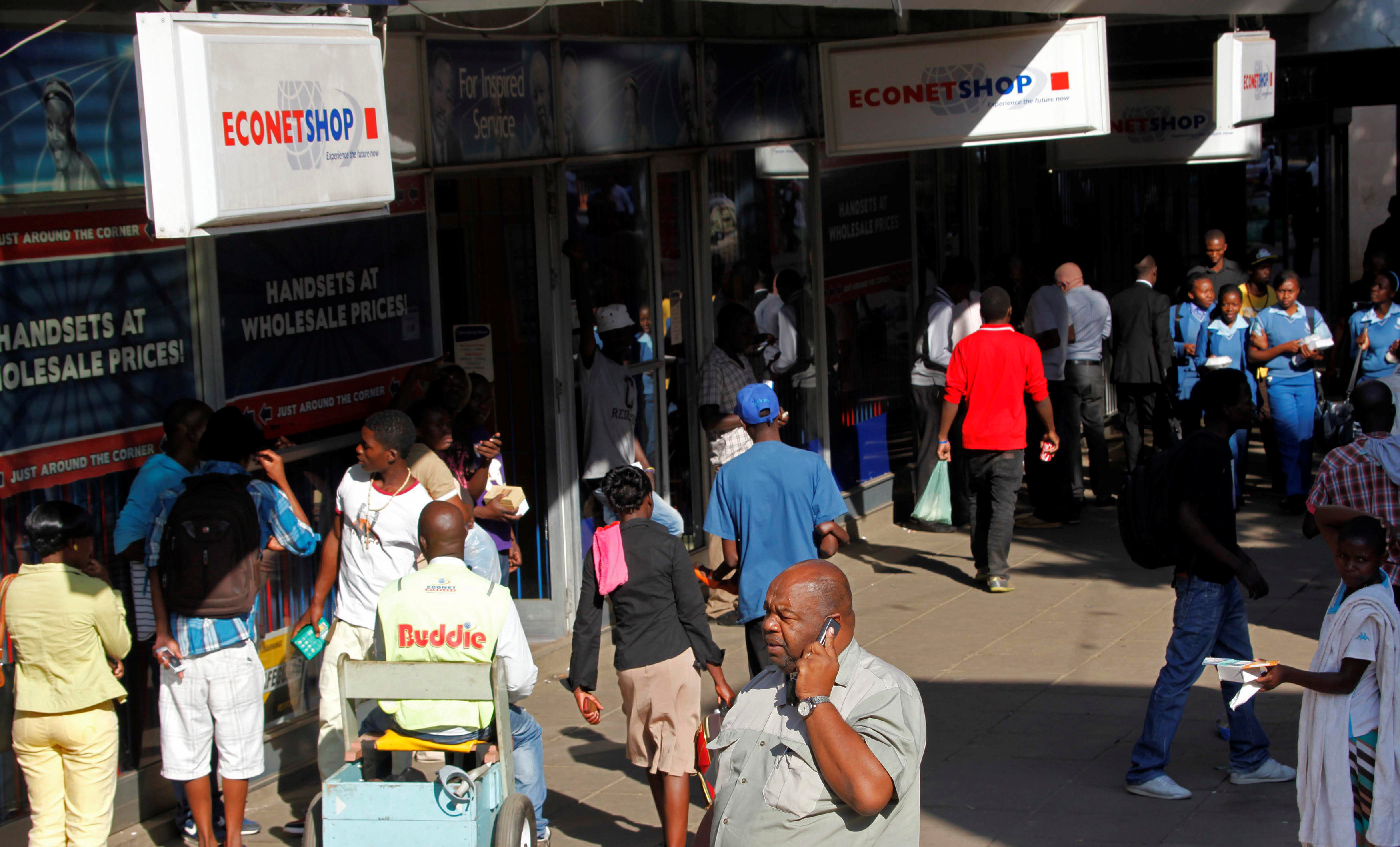 File: A Zimbabwean man speaks on his phone outside a branch of mobile service provider Econet Wireless in central Harare, June 6, 2014.