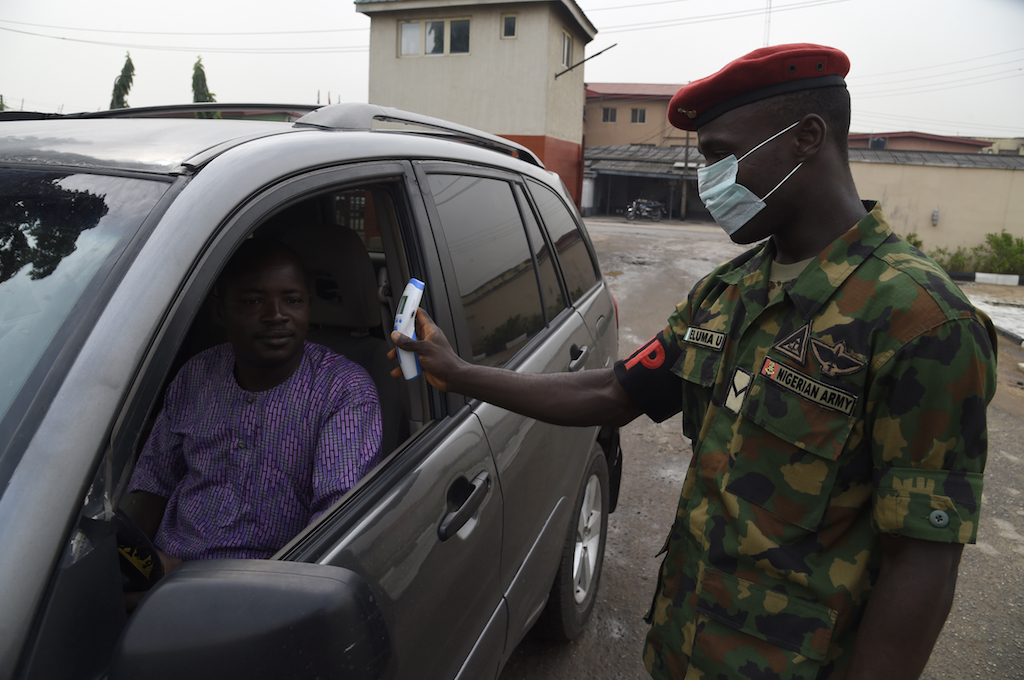 A soldier checks the body temperature of a visitor in a car to the 68 Nigerian Army Reference Hospital at Yaba in Lagos, on February 28, 2020. 