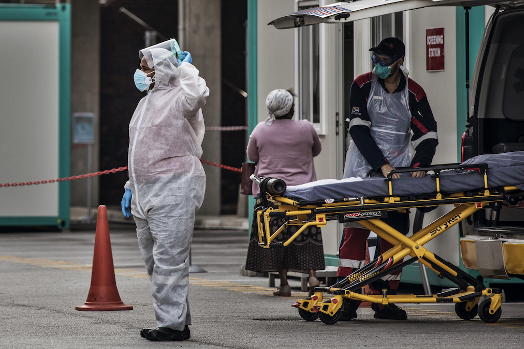 Emergency paramedics wearing a full COVID-19 coronavirus personal protective equipment (PPE) transfer an empty gurney to an ambulance at the Greenacres Hospital in Port Elizabeth.