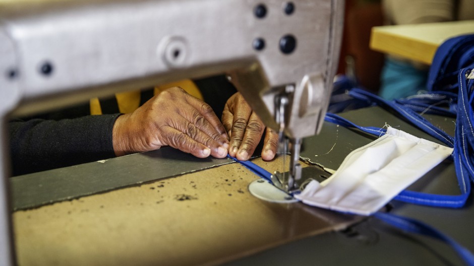 An elderly woman sews cotton fabric used to manufacture reusable face masks in Johannesburg's Alexandra township.