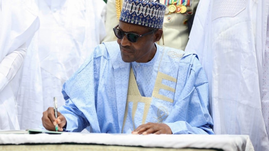 Nigerian President Muhammadu Buhari signs a register during a ceremony to mark the 59th anniversary of Nigeria's independence from England, on October 1, 2019 at the presidency in Abuja.