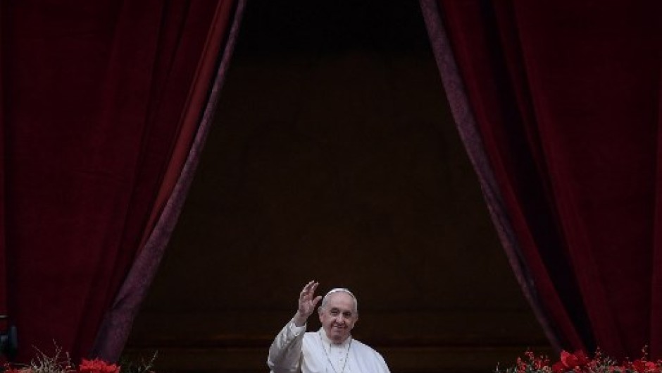 Pope Francis waves to the gathered faithful following his Christmas Urbi et Orbi blessing in St. Peter's Square at The Vatican on December 25, 2021 .
