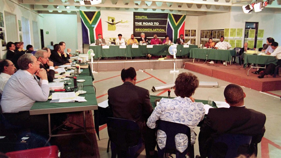 File: Winnie Madikizela-Mandela flanked by her legal representatives at the Truth and Reconciliation Commission (TRC) hearing in Johannesburg on 24 November. ODD ANDERSEN / AFP