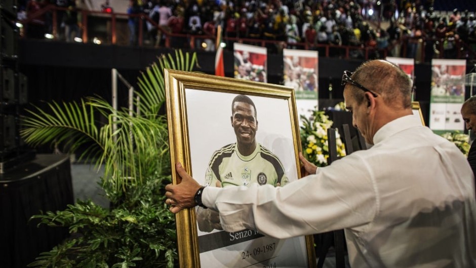 A memorial marshall places the portrait of Senzo Meyiwa during a memorial for the late National Team Captain and Orlando Pirates goalkeeper Senzo Meyiwa, Olympic champion Mbulaeni Mulaudzi and boxer Phindile Mwelase at the Standard Bank Arena in Johannesburg Central District on October 30, 2014