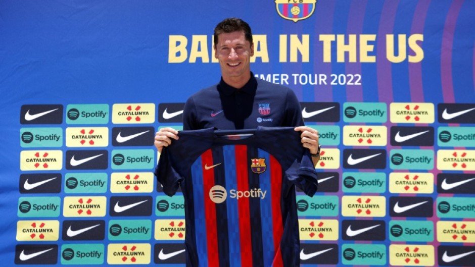 If the cap fits: Robert Lewandowski about to try on a Barcelona shirt after joining the club in July