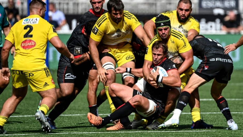 Lyon's South African number 8 Arno Botha (C) is challenged during the French Top 14 rugby union match against La Rochelle