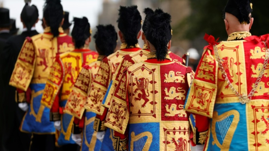 People in Edinburgh watch as members of the Royal Regiment 
of Scotland rehearse before the queen's coffin is conveyed along the Royal Mile to St Giles' Cathedral