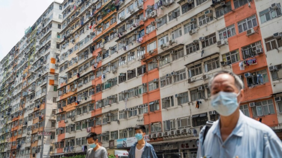 Pedestrians cross a road past apartment blocks in Hong Kong's To Kwa Wan area during intense heat