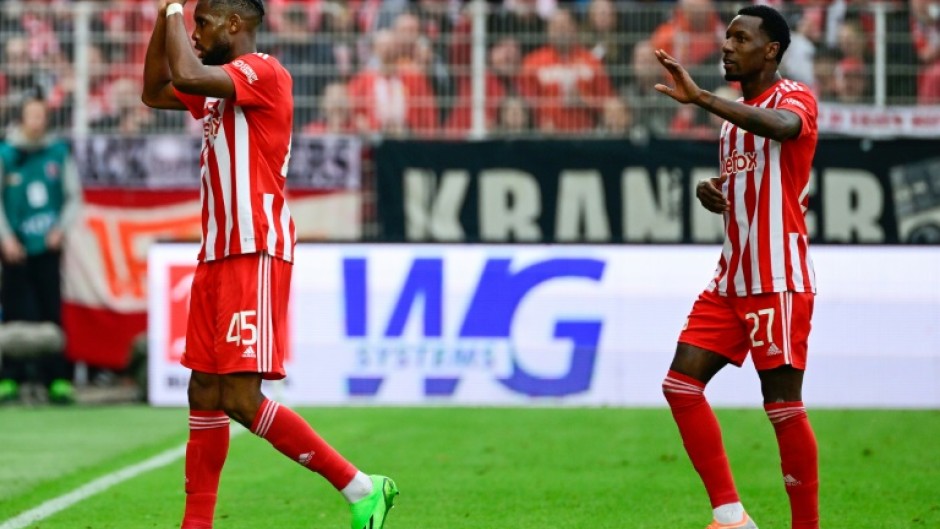 Union Berlin's American forward Jordan Siebatcheu (L) celebrates his goal
