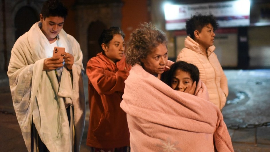 Residents wait in the street in Mexico City after a strong earthquake jolted the capital during the night