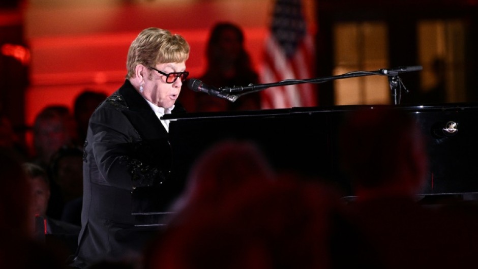 Dressed in a glittering black suit and wearing orange glasses, the 75-year-old pop icon sat down at the piano on the South Lawn of the White House