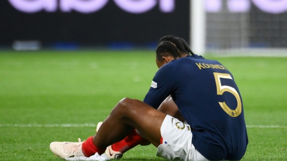 Jules Kounde sits on the pitch after injuring his thigh  playing for France against Austria