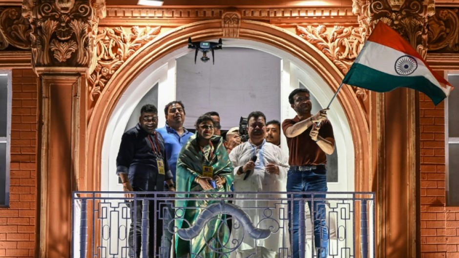 Former Indian cricket captain Sourav Ganguly, right, waves the flag of India during the inauguration of a replica balcony of the Lord's Cricket Ground in London 