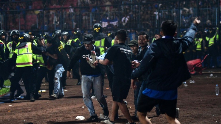 Tragedy: A fan is carried off the pitch 
