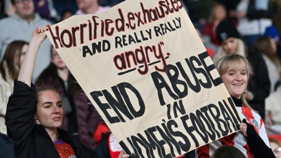 Supporters at Wembley hold up a banner protesting against abuse in women's football