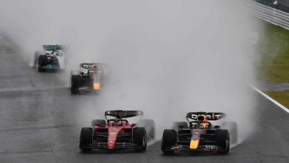Red Bull Racing's Dutch driver Max Verstappen (R) and Ferrari's Monegasque driver Charles Leclerc (C) take the first turn at the start of the Formula One Japanese Grand Prix at Suzuka, Mie prefecture on October 9, 2022.