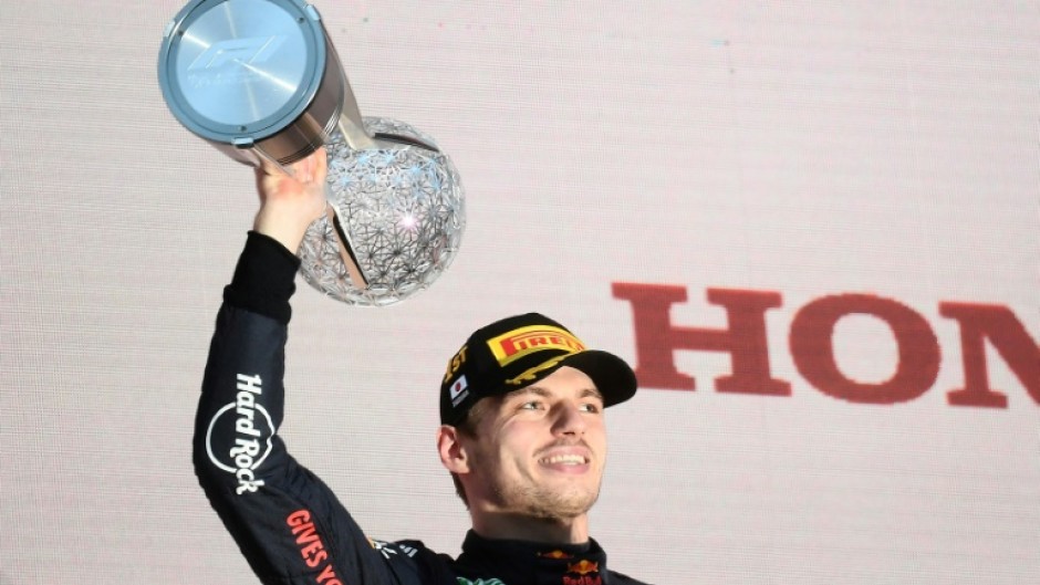 Red Bull Racing's Dutch driver Max Verstappen poses on the podium with the trophy following his victory at the Formula One Japanese Grand Prix at Suzuka, Mie prefecture on October 9, 2022.