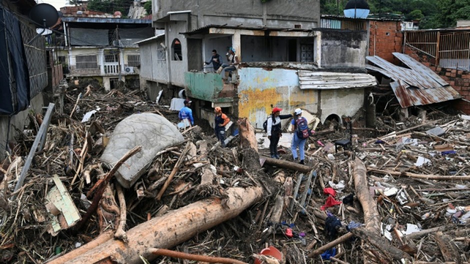 Rescuers and residents search through the rubble for victims or survivors of the landslide in Las Tejerias