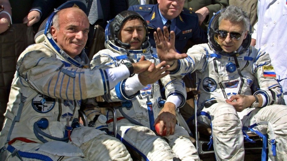 US space tourist Dennis Tito (L) shakes hands with his crew members Talgat Musabayev (C) and Yuri Baturin (R) after their landing near the Kazakh town of Arkalyk (some 300 km from Astana), 06 May 2001