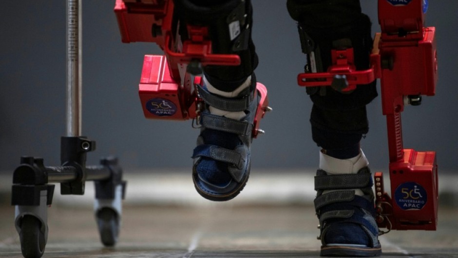 Eight-year-old David Zabala walks with the help of a robotic exoskeleton during a rehabilitation session in Mexico City