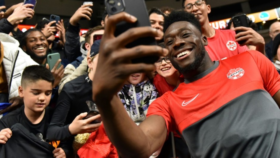 Man of the people: Davies takes a selfie with fans after a CONCACAF Nations League game in June