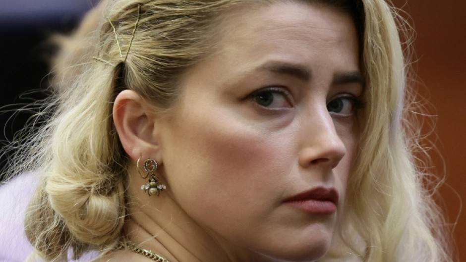 Actress Amber Heard says she has reached a settlement in the defamation case brought against her by her ex-husband Johnny Depp