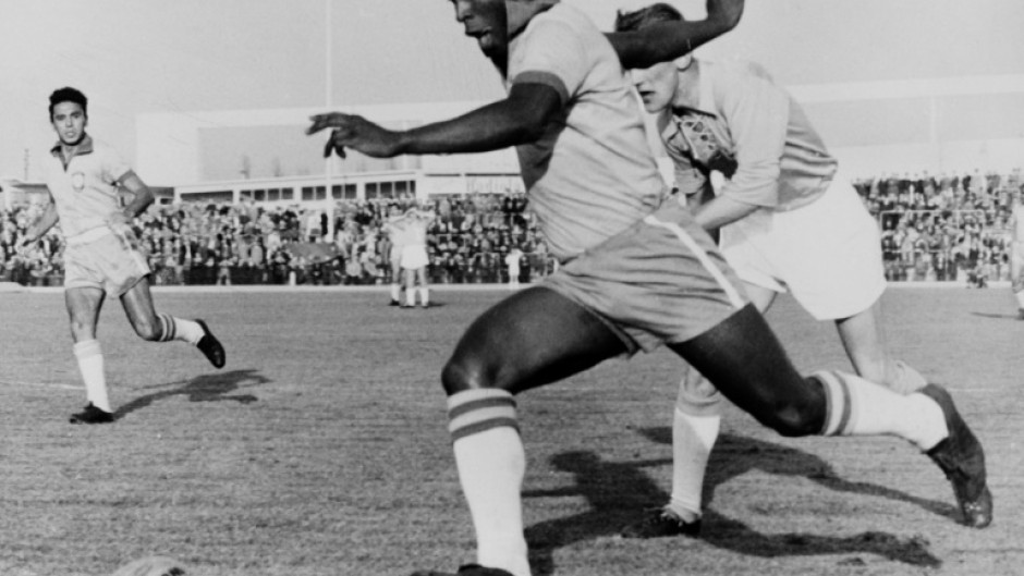 In this photo taken on May 8, 1960, Brazilian football legend Pele dribbles past a defender during a friendly match between Malmo and Brazil, in Sweden