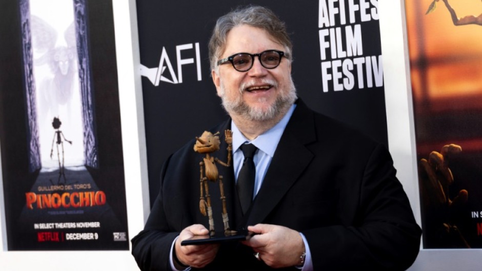 Mexican director Guillermo del Toro holds a wooden puppet as he arrives for the premiere of 'Pinocchio' during the 2022 American Film Institute Festival in Hollywood