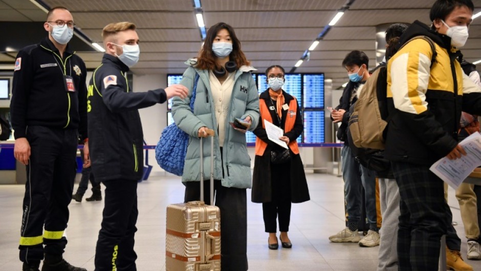 Passengers wait for their vaccination documents to be checked after arriving at Paris's Charles de Gaulle hub after France introduced random testing