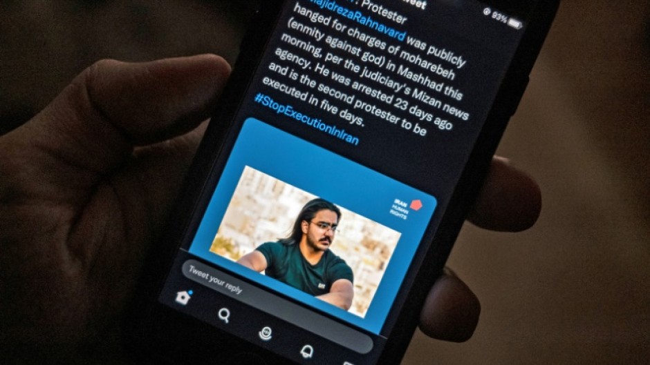 A person in the Cypriot capital Nicosia checks a mobile phone displaying a tweet about the execution of Majidreza Rahnavard