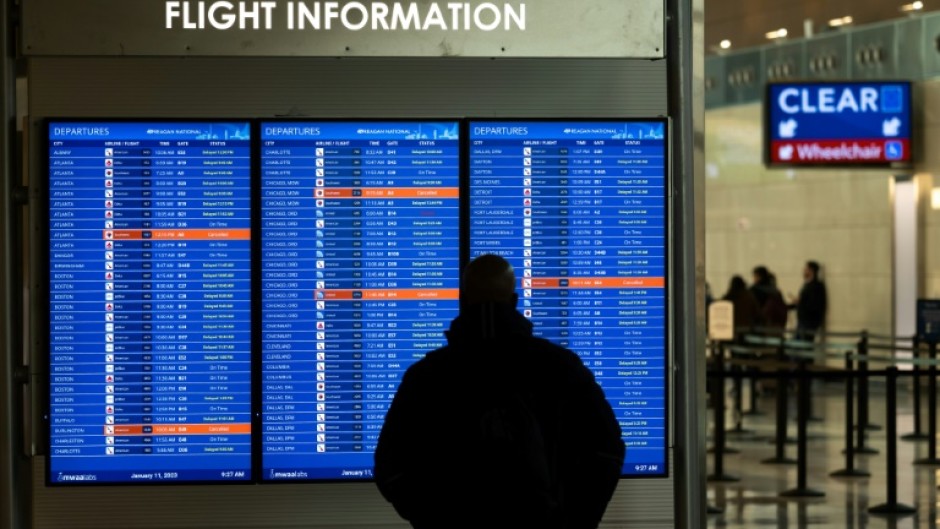 A traveler looks at a display listing cancelled and delayed flights at Ronald Reagan Washington National Airport in Virginia on January 11, 2023
