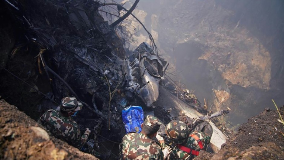 Rescuers inspect the site of a plane crash in Pokhara, Nepal