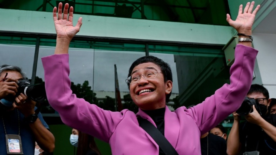 Nobel Prize winner Maria Ressa waves to supporters Wednesday after her acquittal on all four charges of tax evasion filed against her