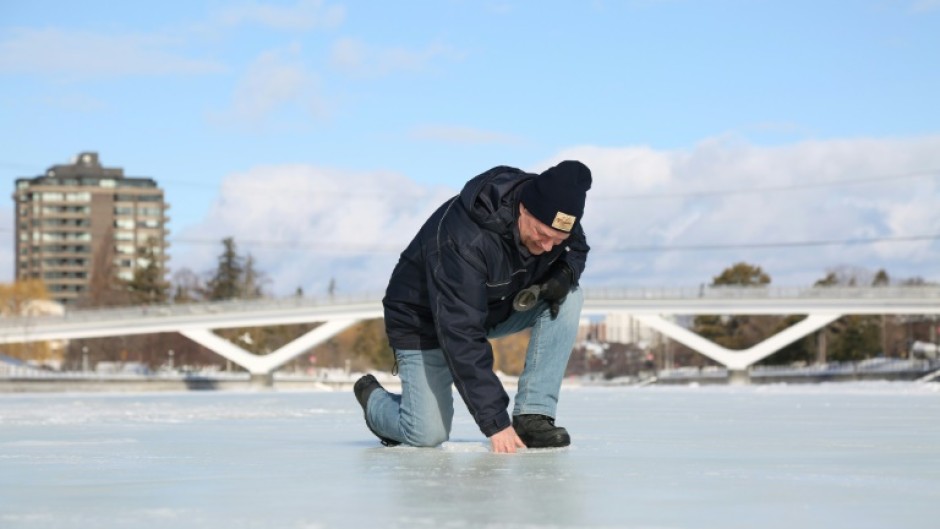 Bruce Devine, senior manager facilities and programs at the National Capital Commission checks the ice condition on the Rideau Canal on February 8, 2023 in Ottawa, Canada 