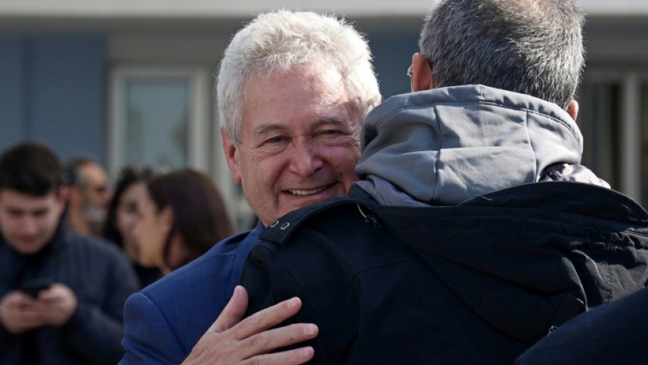 A supporter greets presidential candidate Andreas Mavroyiannis after he cast his vote at a polling station in Nicosia