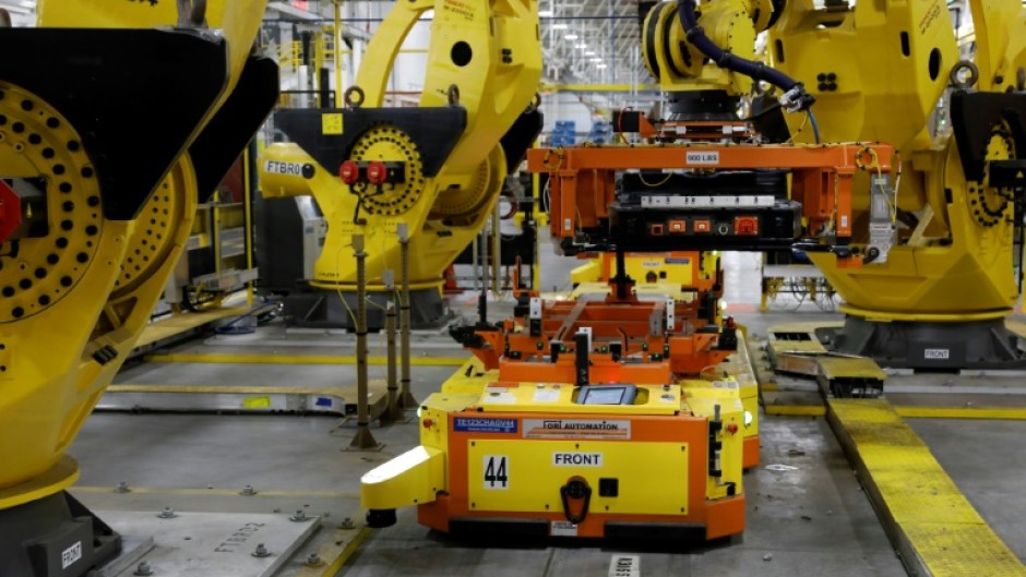 A robot lifts a battery for installation in a Ford F-150 Lightning in Dearborn, Michigan in September 2022 