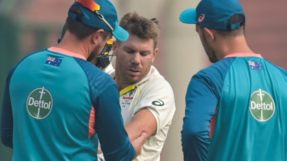 Australia's David Warner gets treatment on his elbow during the opening day of the second Test against India in Delhi