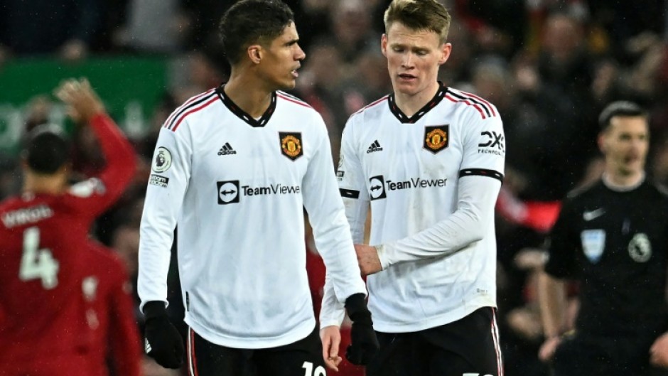 Manchester United's Raphael Varane (L) and Scott McTominay react to their historic defeat at Liverpool