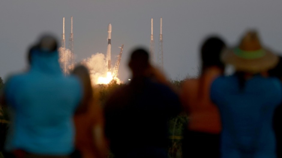 People watch as a SpaceX Falcon 9 rocket lifts off at Cape Canaveral Space Force Station on February 27, 2023 