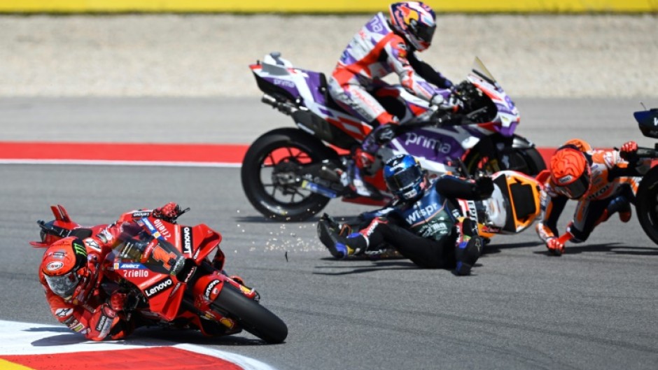 Francesco Bagnaia (left) avoids the crash that wiped out Marc Marquez (right) and Miguel Oliveira