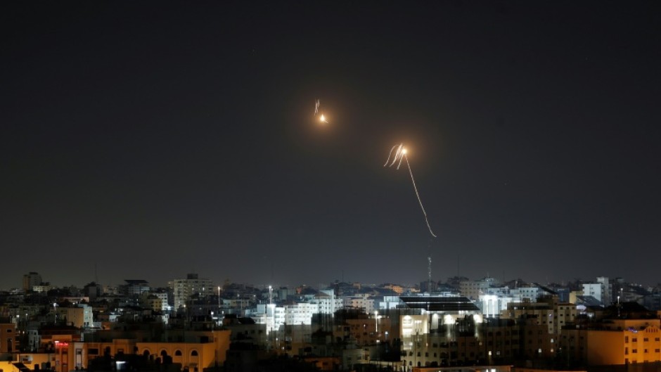 Streaks of light are seen in the sky as Israeli air defences intercept rocket fire from the Gaza Strip