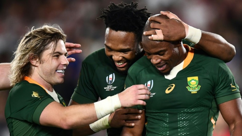 Springboks Faf de Klerk (L) and Lukhanyo Am (C) congratulate try scorer Makazole Mapimpi during the 2019 Rugby World Cup final against England in Yokohama.
