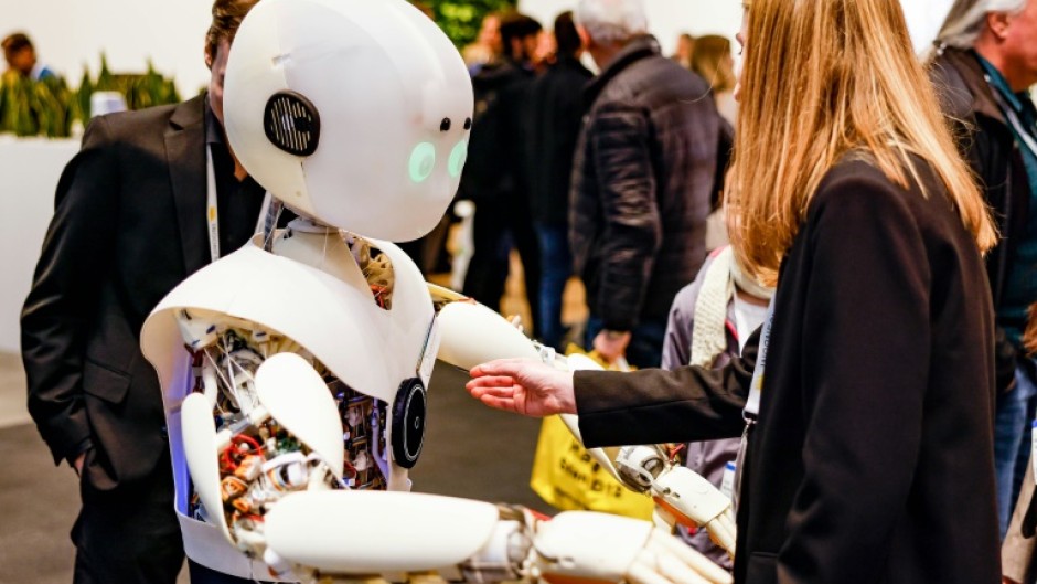 A woman interacts with a robot at a major trade fair in Hanover