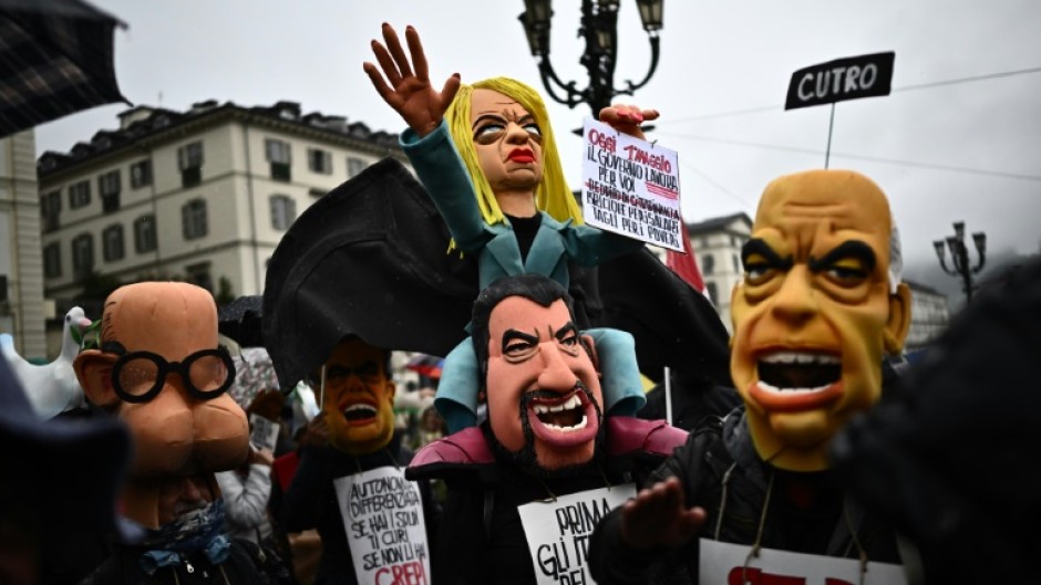 Demonstrators with a puppet of Italy's Prime Minister Giorgia Meloni, centre, at a May Day rally in Turin